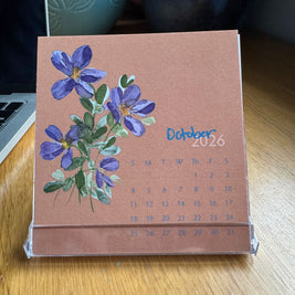 Calendar with floral design on a wooden surface October 2026
