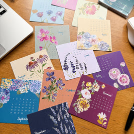 mini desk calendar spread out on a  wooden desk
