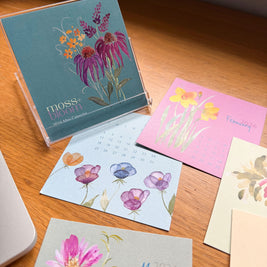 A colorful mini desk calendar on a wooden surface