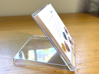 Acrylic stand holding a mini desk calendar on a wooden surface