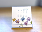 Calendar with floral design on a wooden surface